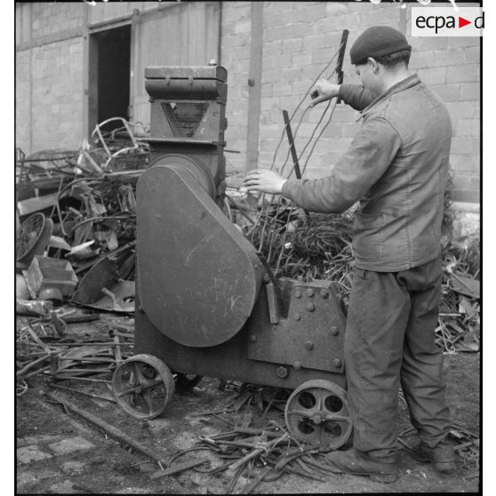 Des ouvriers effectuent un tri dans l'entassement de ferraille à l'extérieur de l'usine.
