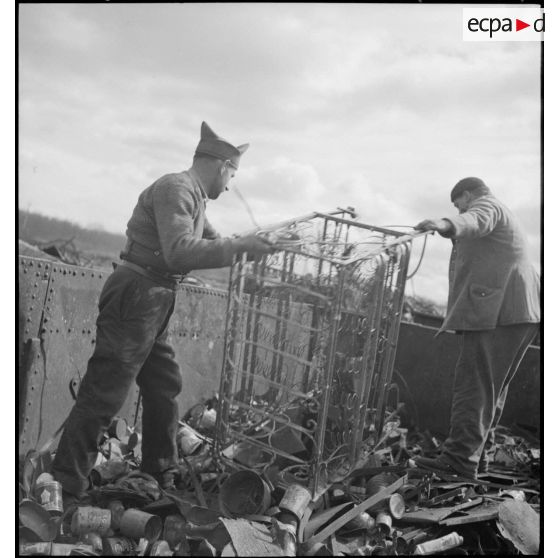 Des ouvriers effectuent un tri dans l'entassement de ferraille à l'extérieur de l'usine.