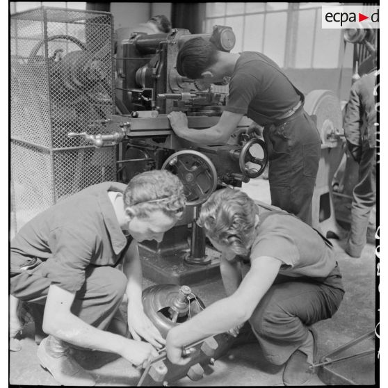 Des élèves apprentis travaillent en atelier sur une machine-outil.