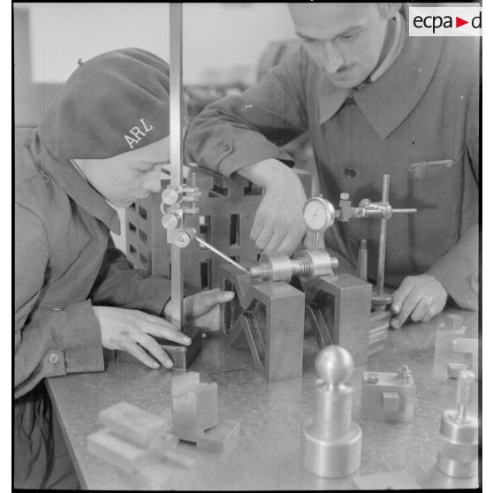 En atelier un professeur assiste un élève.