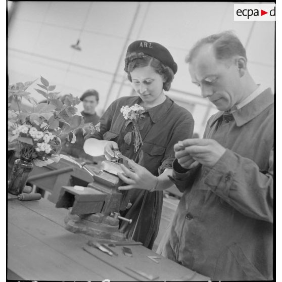 En atelier un professeur assiste une élève.