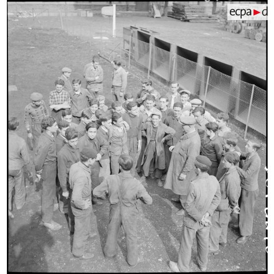 Photographie de groupe d'apprentis rassemblés dans une cour.