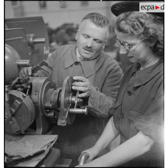 En atelier un professeur assiste une élève.