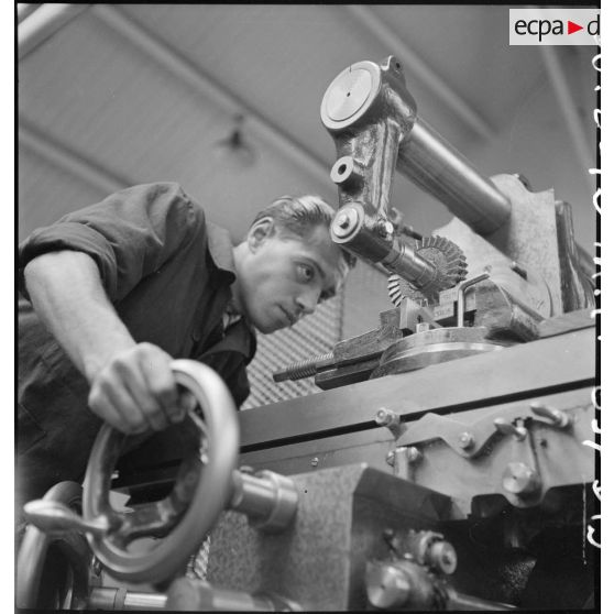 En atelier un apprenti de la cartoucherie de Vincennes travaille sur une machine-outil.