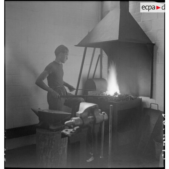 Des élèves apprentis de Sevran travaillent devant le foyer d'une forge.