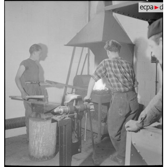 Des élèves apprentis de Sevran travaillent devant le foyer d'une forge.