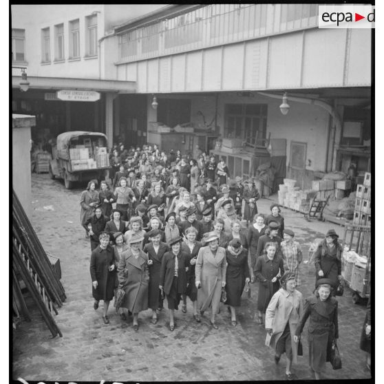 Photographie de groupe des ouvrières à la sortie des ateliers du Bon Marché.