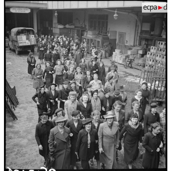 Photographie de groupe des ouvrières à la sortie des ateliers du Bon Marché.