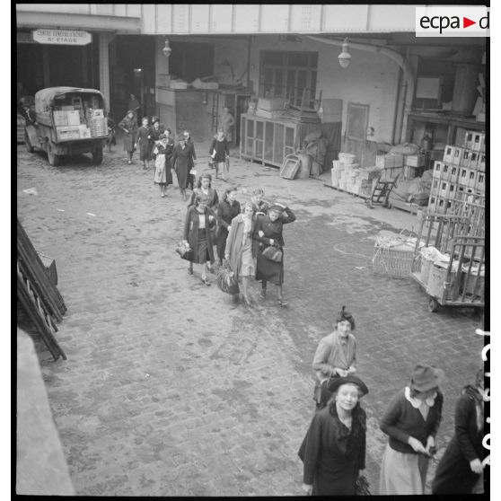 Photographie de groupe des ouvrières à la sortie des ateliers du Bon Marché.