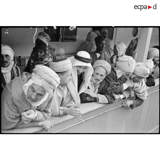 Plan moyen des pélerins accoudés au bastingage du "Gouverneur général Gueydon" qui accoste au port d'Alger.