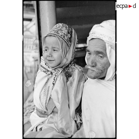 Portrait de groupe d'un pélerin qui tient un enfant dans ses bras.