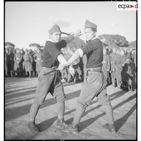 Simulacre de combat au coupe-coupe entre deux tirailleurs indochinois.