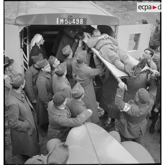 Exercice d'évacuation d'un blessé à bord d'une ambulance Chevrolet de la Section sanitaire de volontaires américains n°1 (SSVA).