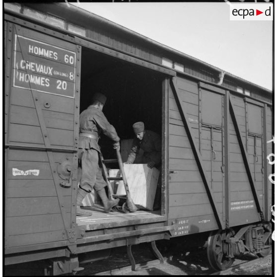 Des soldats chargent un wagon.