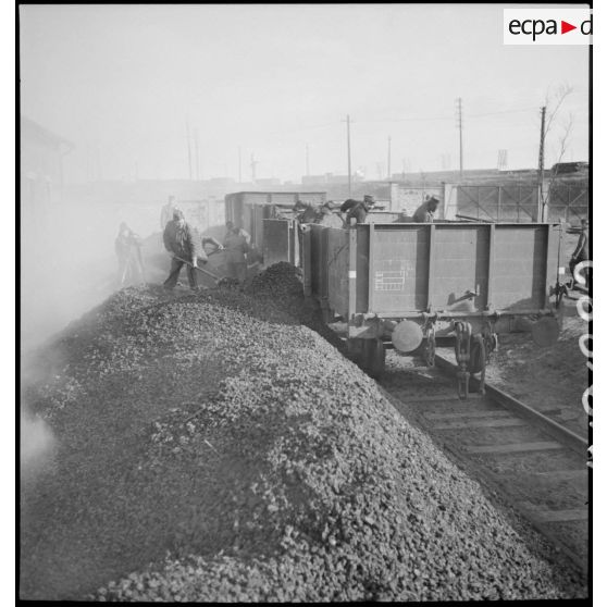 Plan général de soldats qui chargent un wagon ouvert.