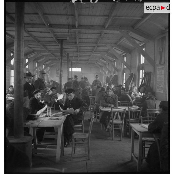 Des permissionnaires sont en transit dans une salle d'attente de la gare de Massy-Palaiseau.