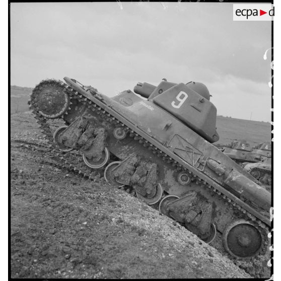 Un char léger Hotchkiss M39 de la 3e DLM franchit un remblai de terre.