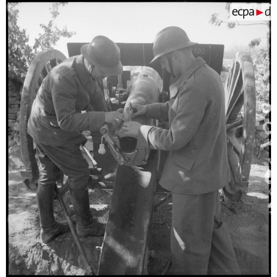 Deux artilleurs mesurent l'angle de pointage de leur canon de 75 mm modèle 1897.
