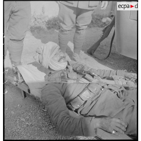 Plan moyen d'un blessé du 2e RSA de la 3e BS couché sur un brancard.