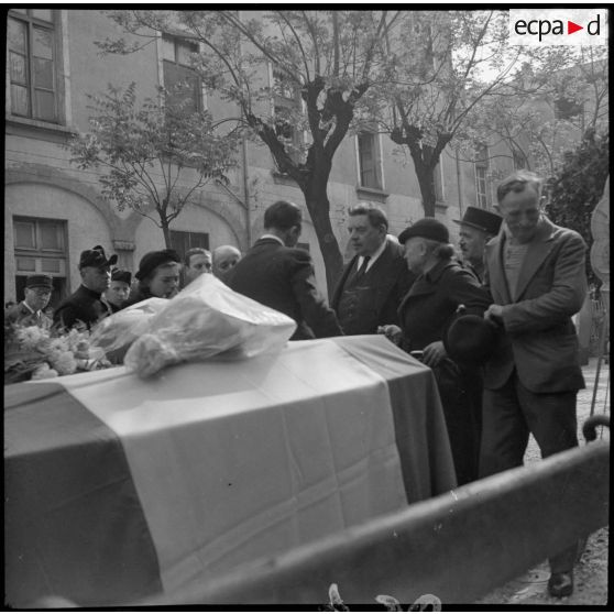 Plan moyen des cercueils exposés lors des obsèques des victimes d'un bombardement.