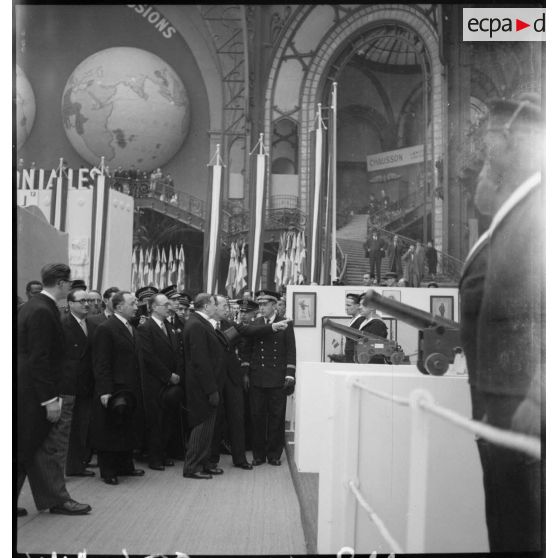 Monsieur Georges Mandel se tient devant un stand de l'exposition la France d'outremer.