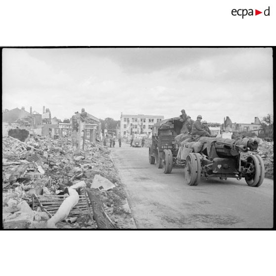 Une pièce d'artillerie tractée traverse les ruines de Vitry-le-François après le bombardement par l'aviation allemande