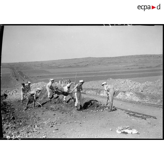 Des légionnaires du 6e REI déblayent des gravats qui encombrent le bord de route.