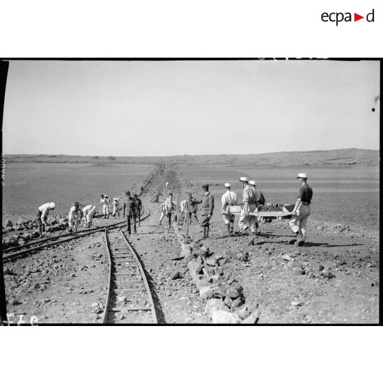Des légionnaires du 6e REI déblayent des gravats qui encombrent le bord de route.