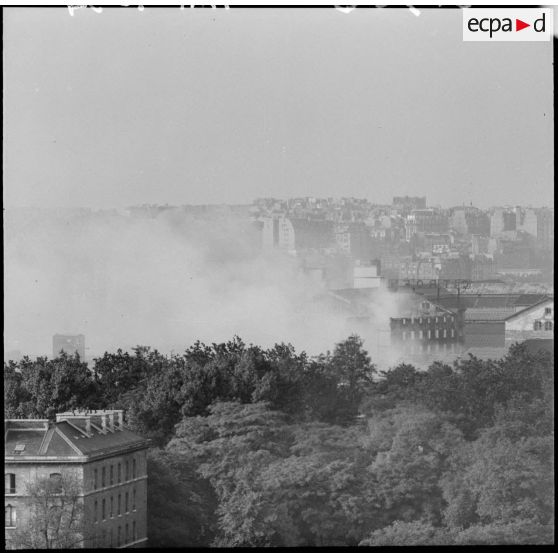 Plan général d'un incendie dans la banlieue parisienne, seule la fumée est visible.