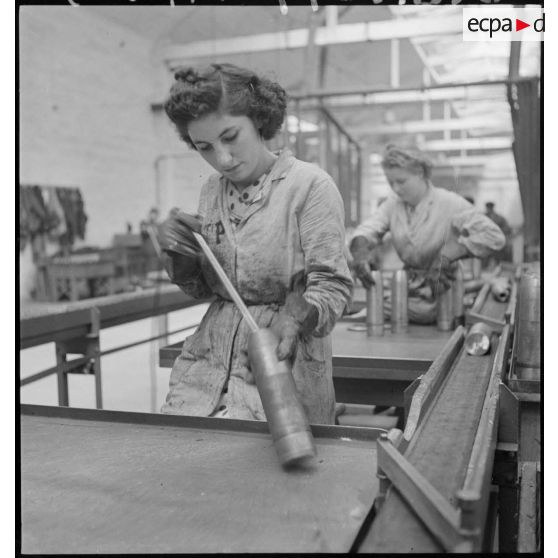 Une ouvrière confectionne un obus.