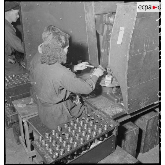 Une ouvrière confectionne un obus.