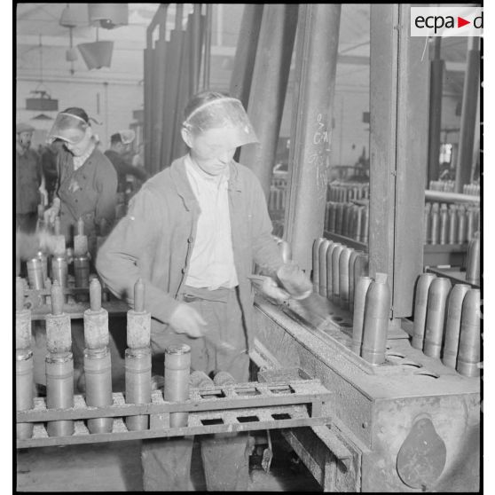 Des ouvriers confectionnent des obus.