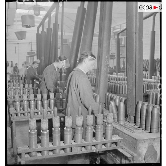 Des ouvriers confectionnent des obus.