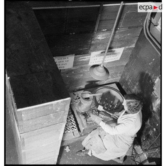 Une ouvrière confectionne des obus.