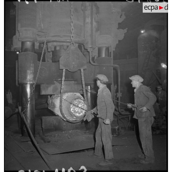 Des ouvriers travaillent devant un marteau-pilon.