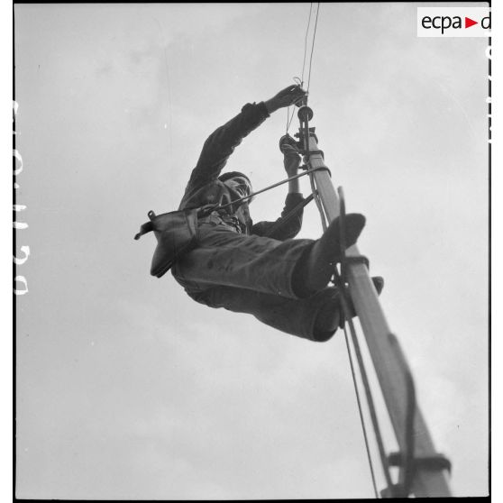 Un élève apprenti de Sevran est photographié en contre-plongée en haut d'un poteau électrique.