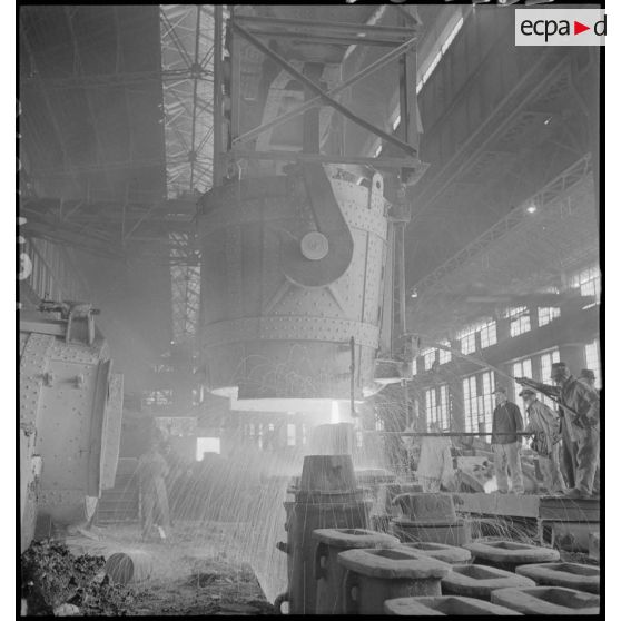 Plan général d'un fourneau auprès duquel des ouvriers s'activent.