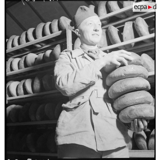 Plan américain d'un soldat qui porte des pains.