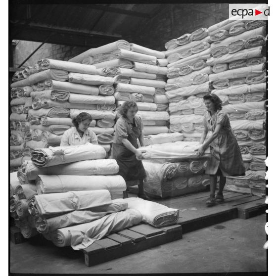 Des ouvrières manipulent des coupons de tissus dans un entrepôt de stockage de l'usine.