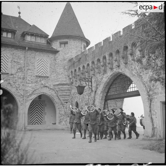 La fanfare du 86e BCA rentre dans la cour d'un château.