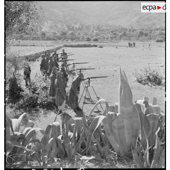 Plan général de jeunes recrues du 1er RTA qui s'exercent au chevalet de pointage sur le terrain d'instruction.