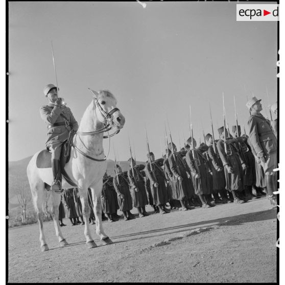 Une compagnie du 1er RTA présente les armes, au premier plan un capitaine à cheval  présente le sabre.