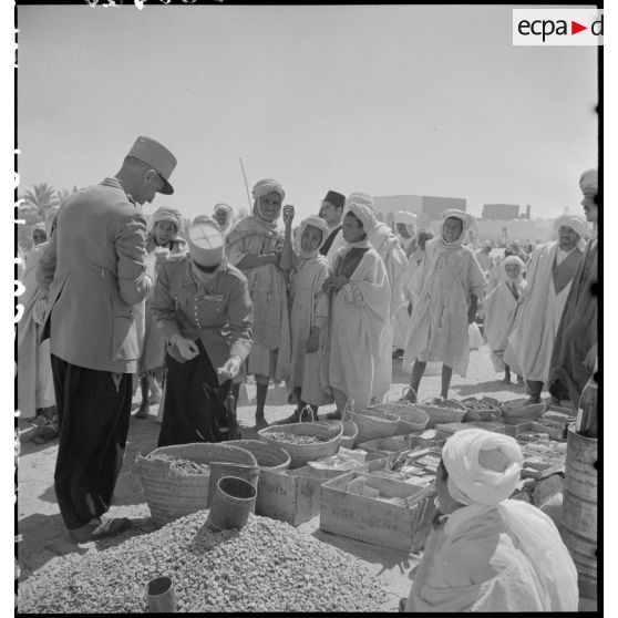 Deux capitaines d'une compagnie des oasis sahariennes vérifient les denrées sur le marché d'El Oued.