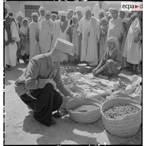 Deux capitaines d'une compagnie des oasis sahariennes vérifient les denrées sur le marché d'El Oued.