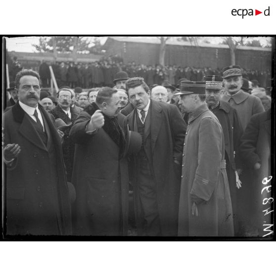 Inauguration de la Foire de Lyon, M. Herriot, maire de Lyon, s'entretient avec les organisateurs qui lui explique le fonctionnement d'un appareil exposé. [légende d'origine]