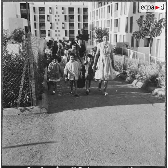 Cité Fougeroux. Rentrée des classes. Par petits groupes les enfants arrivent à l'école.