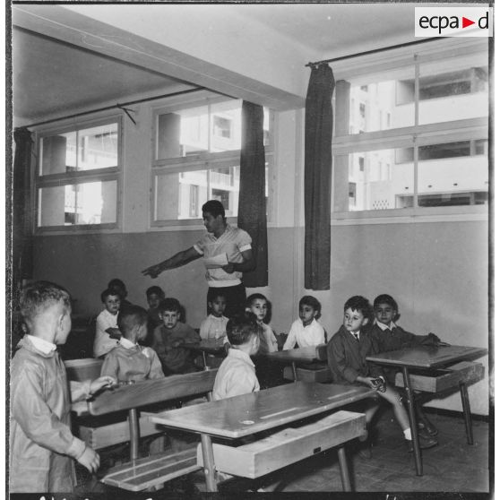 Cité Fougeroux. Rentrée des classes. Les élèves sont déjà attentifs à ce que leur raconte le maître.