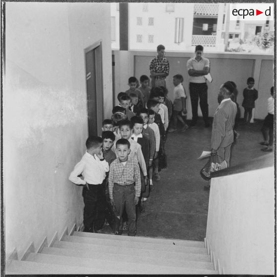 Cité Fougeroux. Rentrée des classes. Les élèves en rang par deux entrent en classe.