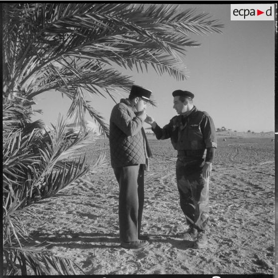 La zone est du Sahara (ZES). Le reporter cinéaste du service cinamétographique des armées (SCA) Gérard Py discute avec un soldat.