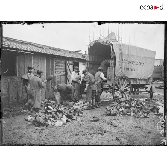 Orléans, aux magasins d'artillerie. Centre de récupération. Déchargement des vieux souliers pour être lavés. [légende d'origine]